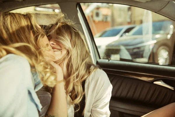 Молоді лесбіянки готуються до відпустки на машині в сонячний день — стокове фото