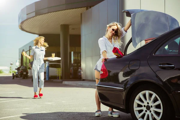 Jóvenes lesbianas se preparan para el viaje de vacaciones en el coche en un día soleado — Foto de Stock