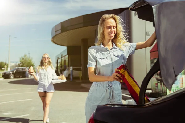 Jóvenes lesbianas se preparan para el viaje de vacaciones en el coche en un día soleado — Foto de Stock