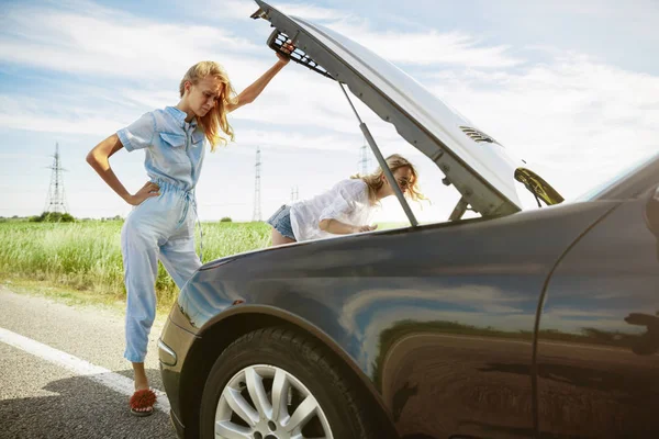 Jóvenes lesbianas se van de viaje de vacaciones en el coche en un día soleado — Foto de Stock