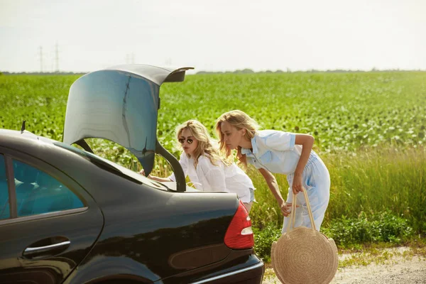 Jóvenes lesbianas se van de viaje de vacaciones en el coche en un día soleado — Foto de Stock