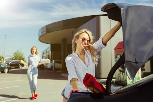 Молодые лесбиянки готовятся к поездке на машине в солнечный день — стоковое фото