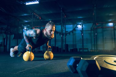 Genç sağlıklı erkek atlet spor salonunda egzersiz yapıyor