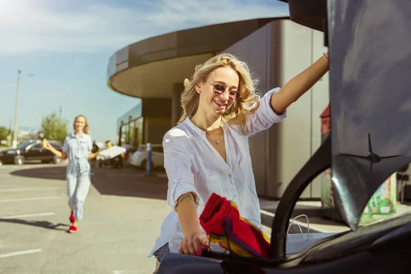 Молоді лесбіянки готуються до відпустки на машині в сонячний день — стокове фото