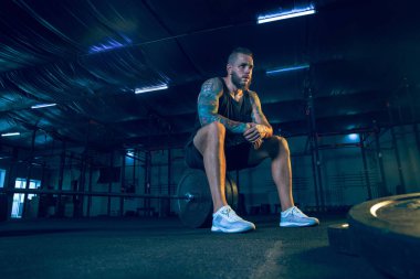 Genç sağlıklı erkek atlet spor salonunda eğitim için hazırlanıyor