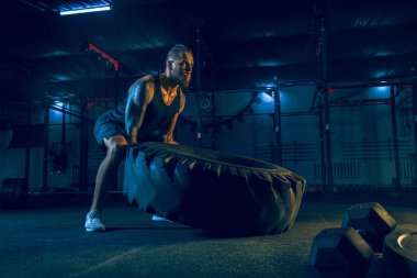 Genç sağlıklı erkek atlet spor salonunda egzersiz yapıyor