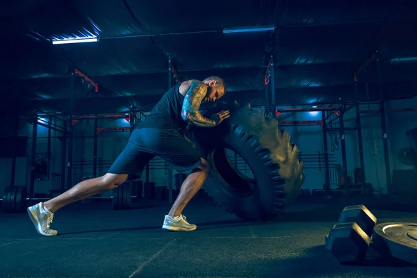 Unga friska man atlet gör övning i gymmet — Stockfoto