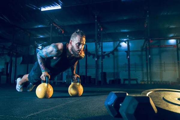 Joven atleta hombre sano haciendo ejercicio en el gimnasio — Foto de Stock