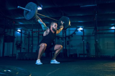 Genç sağlıklı erkek atlet spor salonunda egzersiz yapıyor