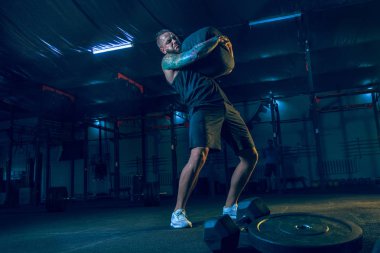 Genç sağlıklı erkek atlet spor salonunda egzersiz yapıyor