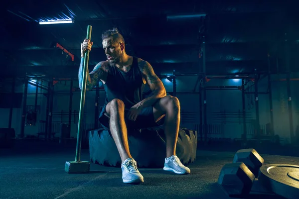 Genç sağlıklı erkek atlet spor salonunda egzersiz yapıyor