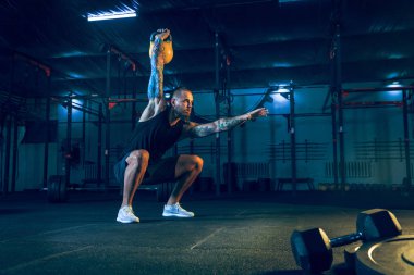 Genç sağlıklı erkek atlet spor salonunda egzersiz yapıyor