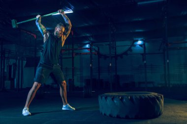 Genç sağlıklı erkek atlet spor salonunda egzersiz yapıyor