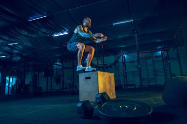 Genç sağlıklı erkek atlet spor salonunda egzersiz yapıyor