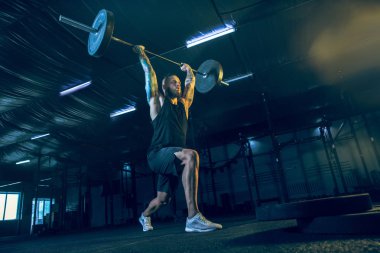 Genç sağlıklı erkek atlet spor salonunda egzersiz yapıyor