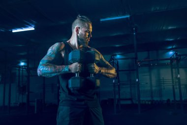 Genç sağlıklı erkek atlet spor salonunda egzersiz yapıyor