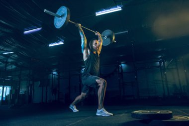 Genç sağlıklı erkek atlet spor salonunda egzersiz yapıyor