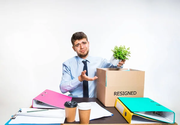 The young man is resigned and folds things in the workplace