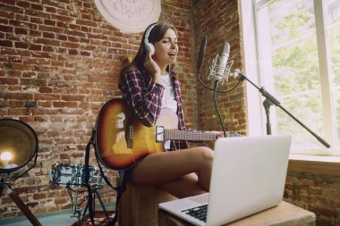 Kadın müzik kayıt, gitar çalmak ve evde şarkı