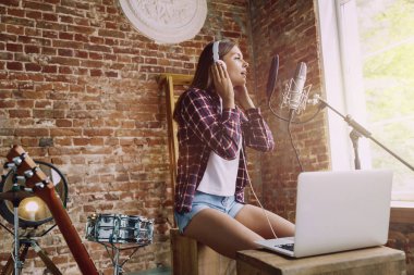 Evde müzik, yayın ve şarkı söyleyen kadın
