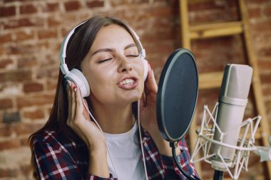 Evde müzik, yayın ve şarkı söyleyen kadın