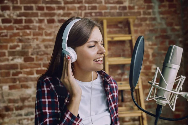 Woman recording music, broadcasting and singing at home