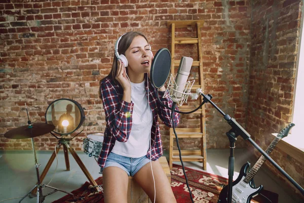 Woman recording music, broadcasting and singing at home