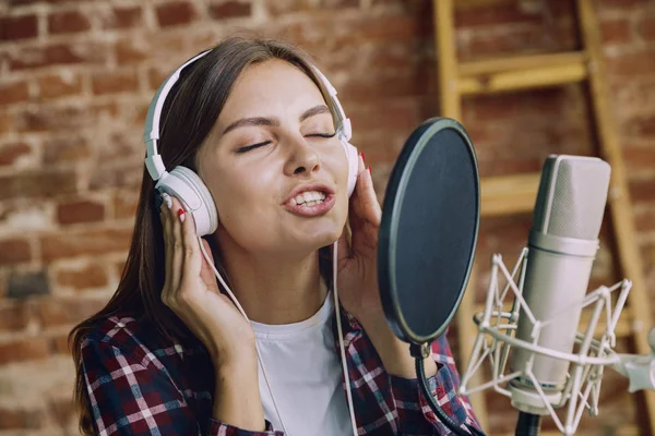 Woman recording music, broadcasting and singing at home