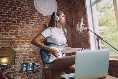 Kadın müzik kayıt, gitar çalmak ve evde şarkı