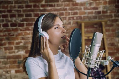 Evde müzik, yayın ve şarkı söyleyen kadın