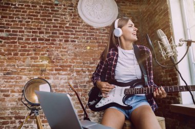 Kadın müzik kayıt, gitar çalmak ve evde şarkı