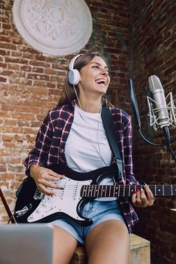 Kadın müzik kayıt, gitar çalmak ve evde şarkı