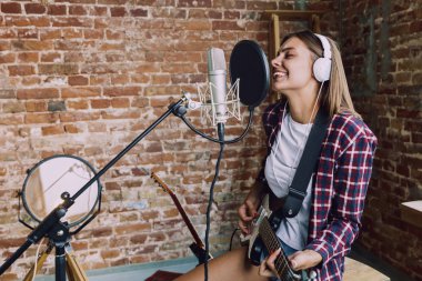 Kadın müzik kayıt, gitar çalmak ve evde şarkı