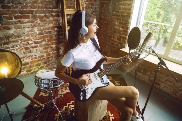 Žena nahrává hudbu, hraje na kytaru a zpívá doma — Stock fotografie