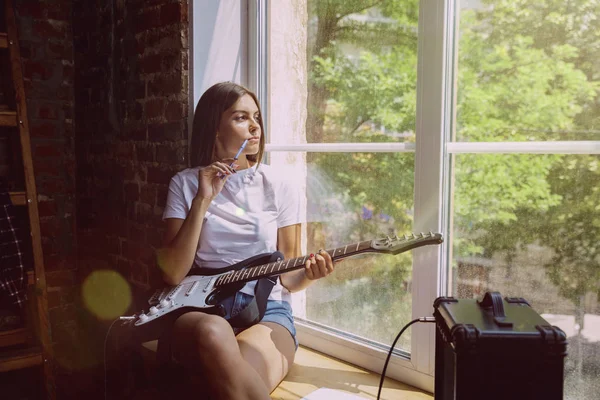 Mulher gravando música, tocando guitarra e cantando em casa — Fotografia de Stock