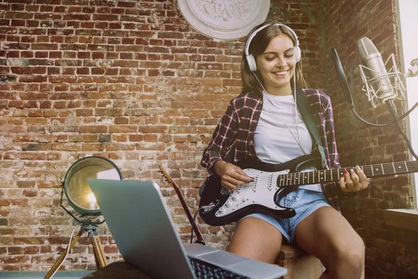 Mujer grabando música, tocando la guitarra y cantando en casa — Foto de Stock