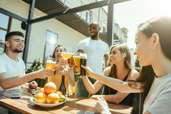 Genç arkadaş grubu bira içip birlikte kutlama yapıyor. — Stok fotoğraf