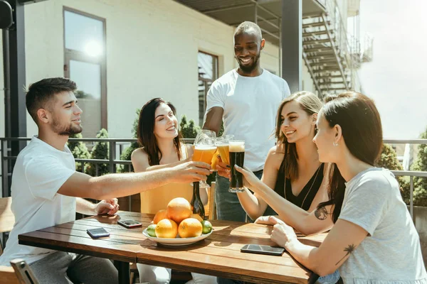 Joven grupo de amigos bebiendo cerveza y celebrando juntos — Foto de Stock