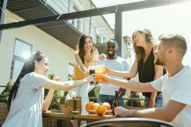 Genç arkadaş grubu bira içip birlikte kutlama yapıyor.