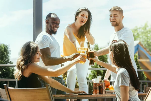 Joven grupo de amigos bebiendo cerveza y celebrando juntos — Foto de Stock