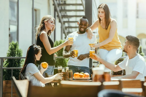 Joven grupo de amigos bebiendo cerveza y celebrando juntos — Foto de Stock