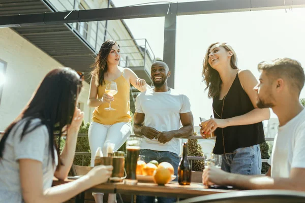 Joven grupo de amigos bebiendo cerveza y celebrando juntos —  Fotos de Stock