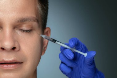 Gri stüdyo arka planda izole genç adam yakın çekim portre