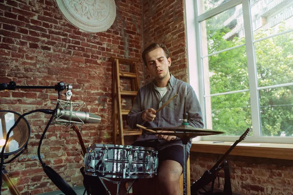 Junger Mann nimmt Musik auf, spielt zu Hause Schlagzeug und singt — Stockfoto