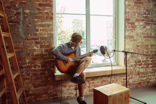 Jonge man muziek opnemen, gitaar spelen en zingen thuis — Stockfoto