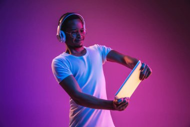 Neon ışıkta müzik dinleyen genç Afrikalı-Amerikan Mans