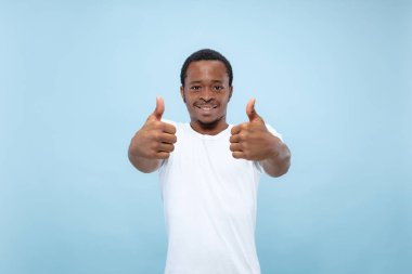 Yarı uzunlukta mavi arka planda genç adamın portre yakın.