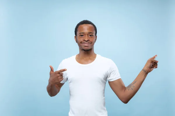 Media longitud primer plano retrato de hombre joven sobre fondo azul . — Foto de Stock