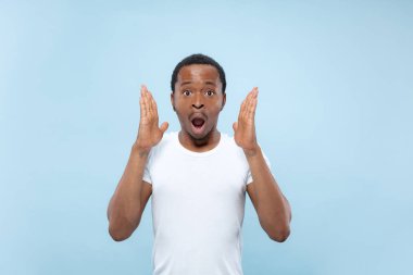 Yarı uzunlukta mavi arka planda genç adamın portre yakın.