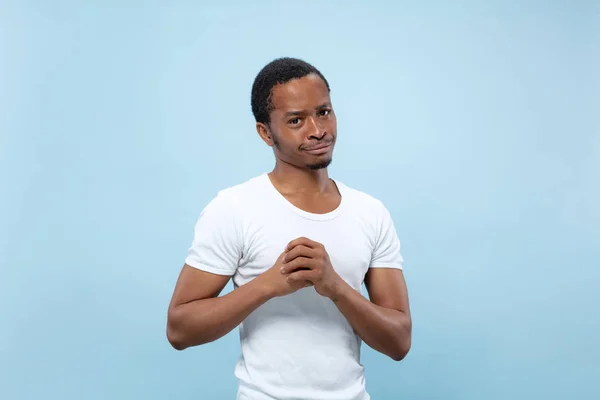 Media longitud primer plano retrato de hombre joven sobre fondo azul . — Foto de Stock